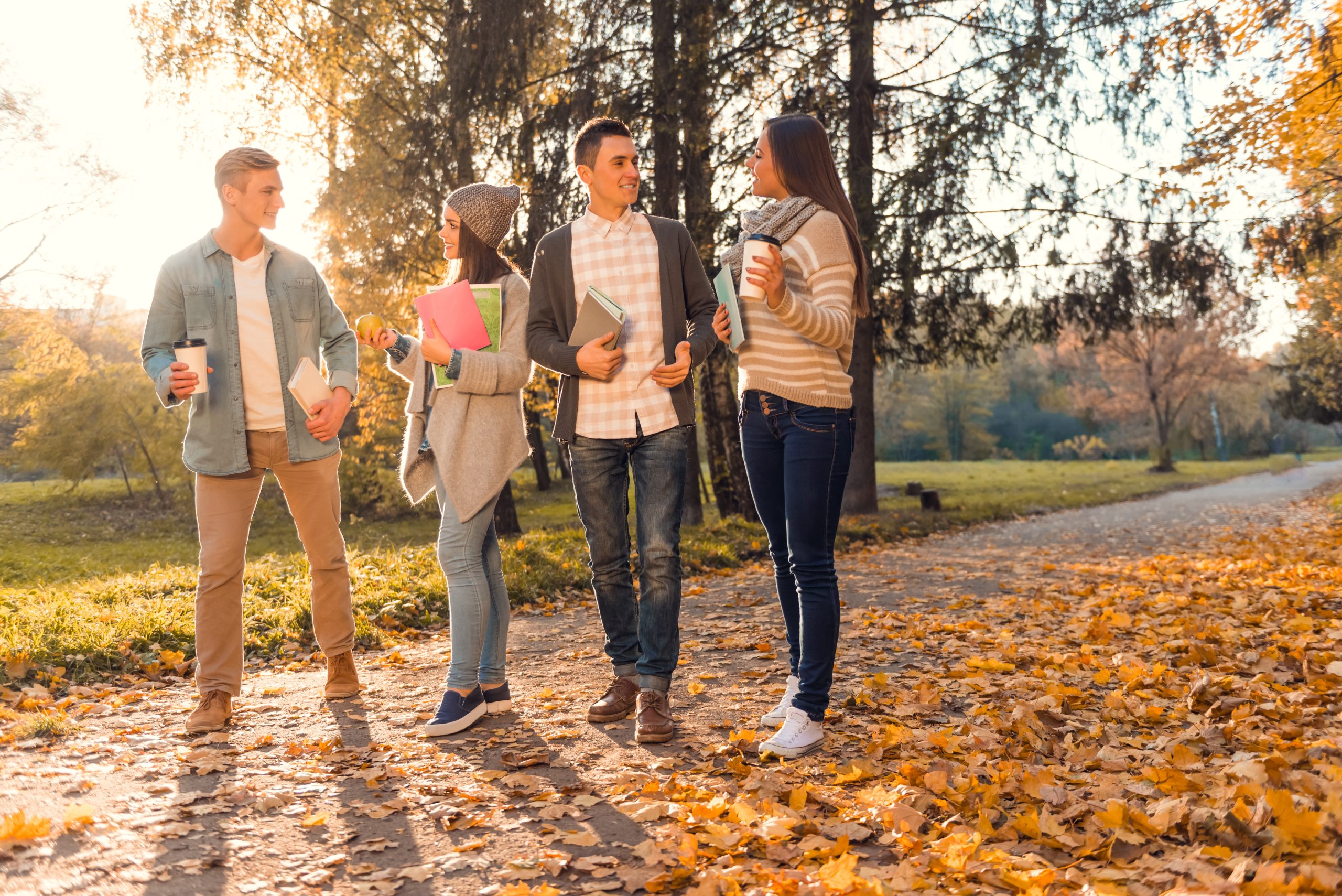 Group of young people students while walking autumn park